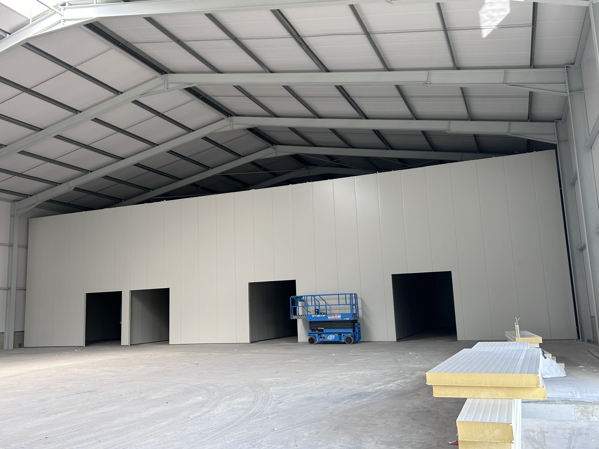 Insulated hall with new partition wall and a scissor lift during fit-out